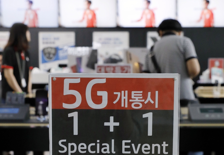 세계 첫 5세대(5G) 네트워크 상용화에 성공한 지 100일째를 맞은 11일 서울 시내 IT기기 체험 공간에서 한 시민이 전시된 휴대폰을 살펴보고 있다. <사진=뉴시스>