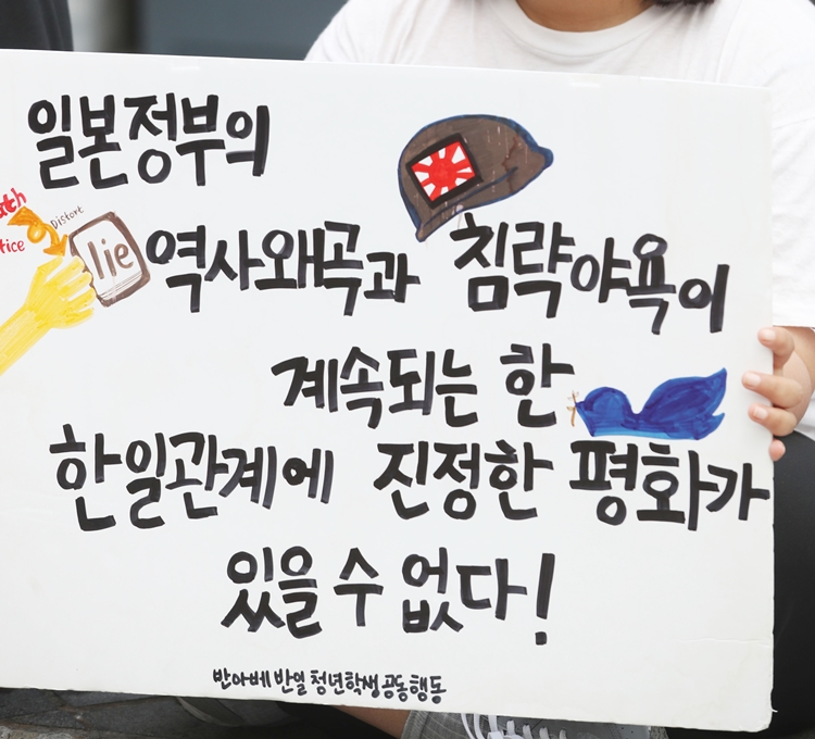 반아베 반일 청년학생공동행동 회원이 지난 6일 서울 종로구 구 일본대사관에서 열린 ‘한일 위안부 합의 규탄 문화제’에서 손피켓을 들고 있다. <사진=뉴시스>