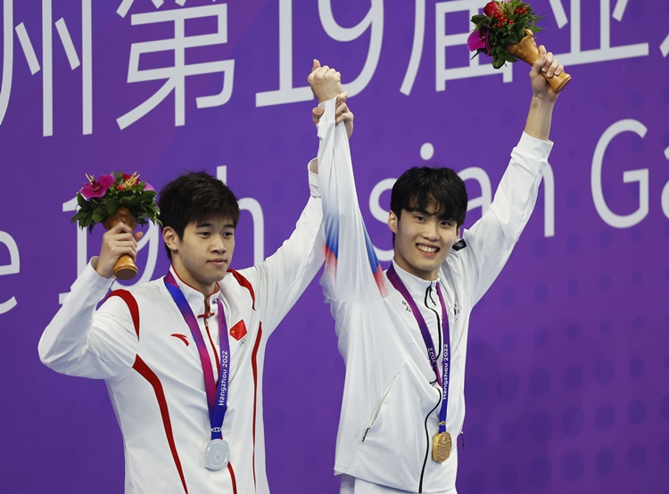 (왼쪽부터) 2022 항저우 아시안게임 남자 자유형 200m에서 은메달을 차지한 중국의 판잔러 선수, 금메달을 차지한 황선우 선수가 지난달 27일 중국 항저우 올림픽 스포츠센터 수영장에서 열린 시상식에서 함께 손을 들고 있다. <사진=뉴시스>