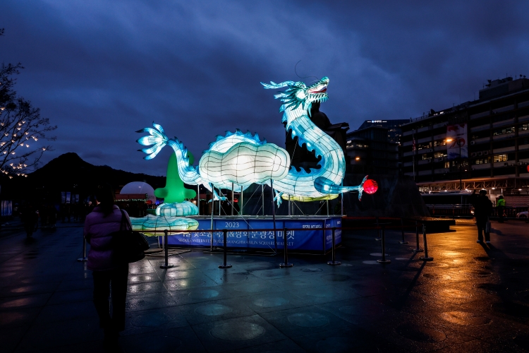 지난 15일 서울 종로구 광화문광장에서 열린 ‘2023 서울빛초롱 축제’를 찾은 시민들이 2024년 갑진년(甲辰年) 청룡의 해를 맞아 제작된 푸른 용 조형물을 바라보고 있는 모습. <사진=뉴시스>