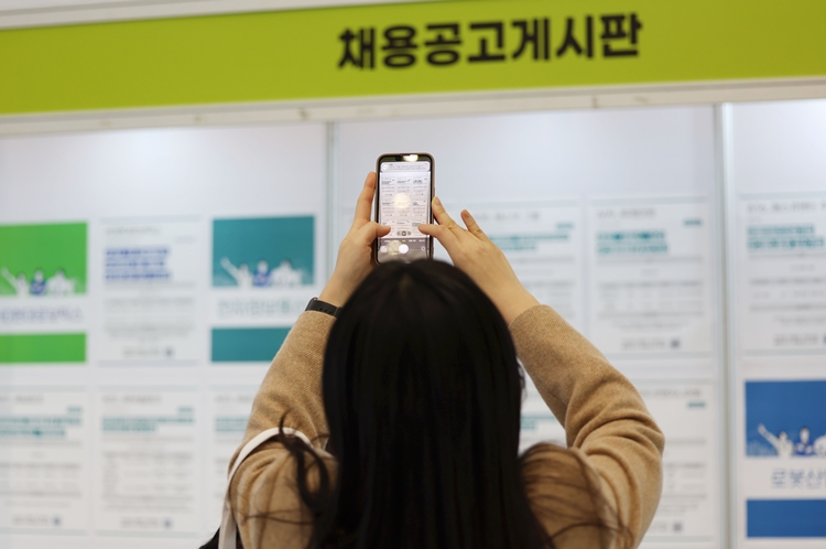 지난 2023년 11월21일 서울 중구 동대문디자인플라자(DDP)에서 열린 ‘참 좋은 동행 일자리 박람회’를 찾은 한 구직자가 채용공고 게시판을 스마트폰에 담고 있는 모습. <사진=뉴시스>